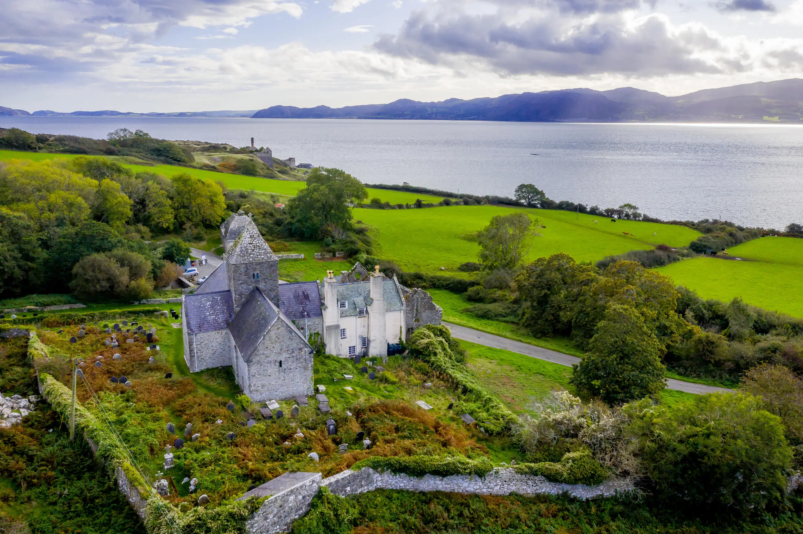 Aerial shot of Penmon priory with Menai Strait and the Great Orme Llandudno in the Background