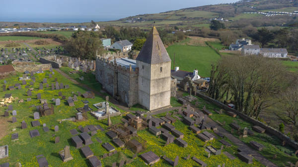 Llaneilian church and spire rising in the foreground with Dulas bay and Irish sea behind