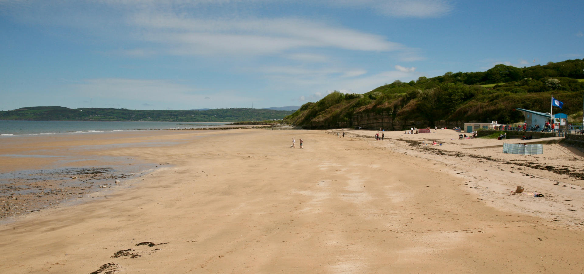 Benllech Beach with the tide out and blue sky.
