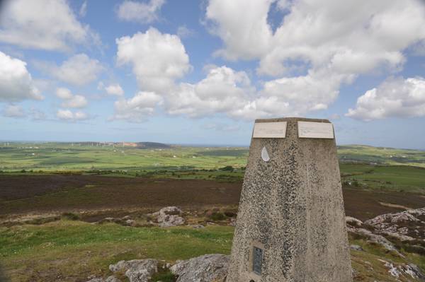 Trig point at the top of bodafon mountain looking towards Parys mountain and Irish sea