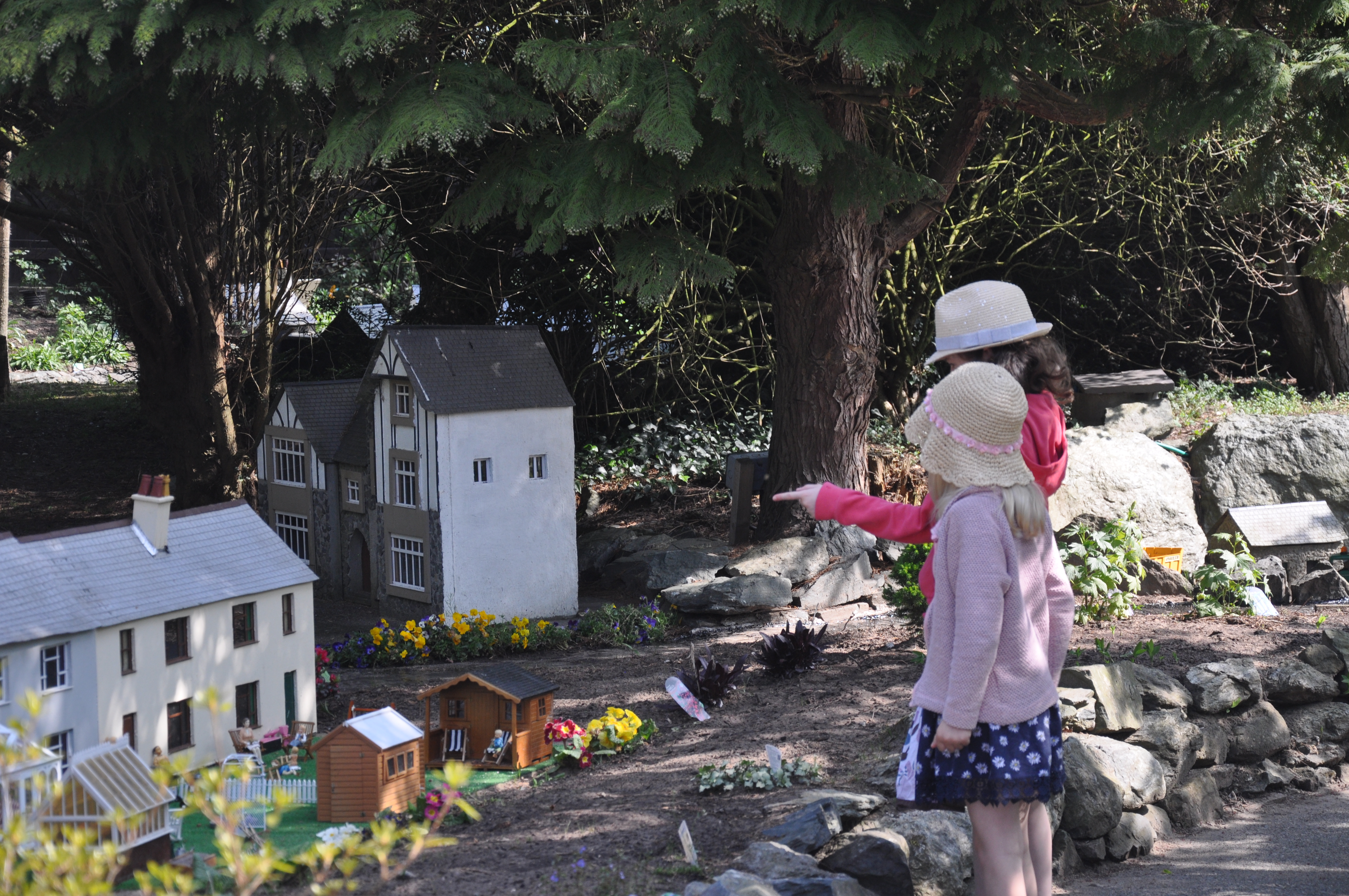 Two small girls pointing at the model house in the sunshine