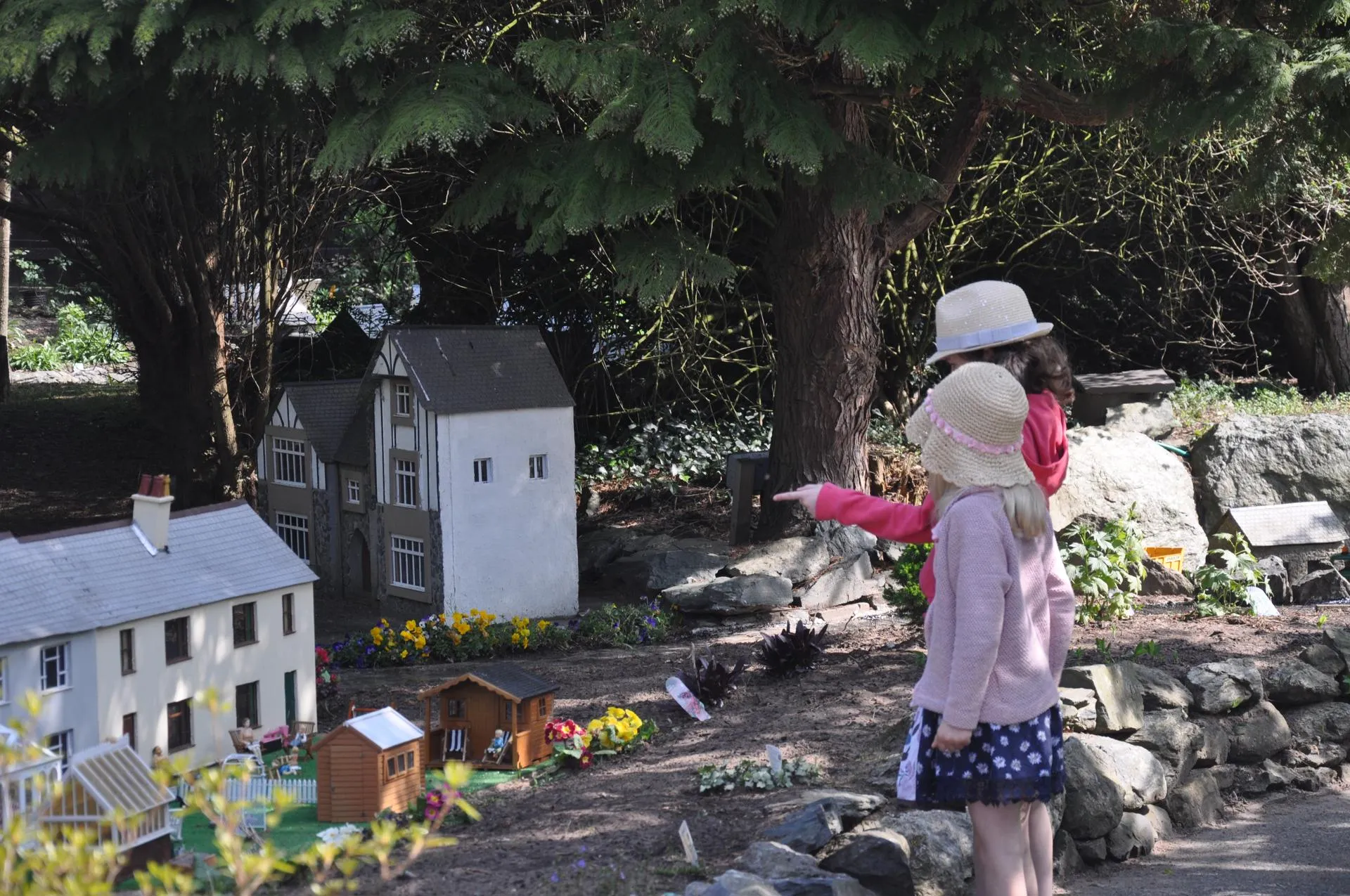 Two small girls pointing at the model house in the sunshine