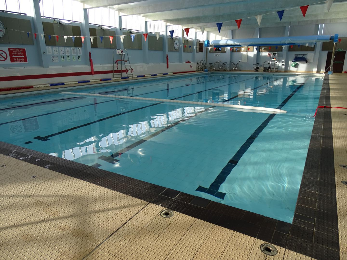 Main Swimming Pool with clear turquoise water and lanes marked out with bunting overhead 