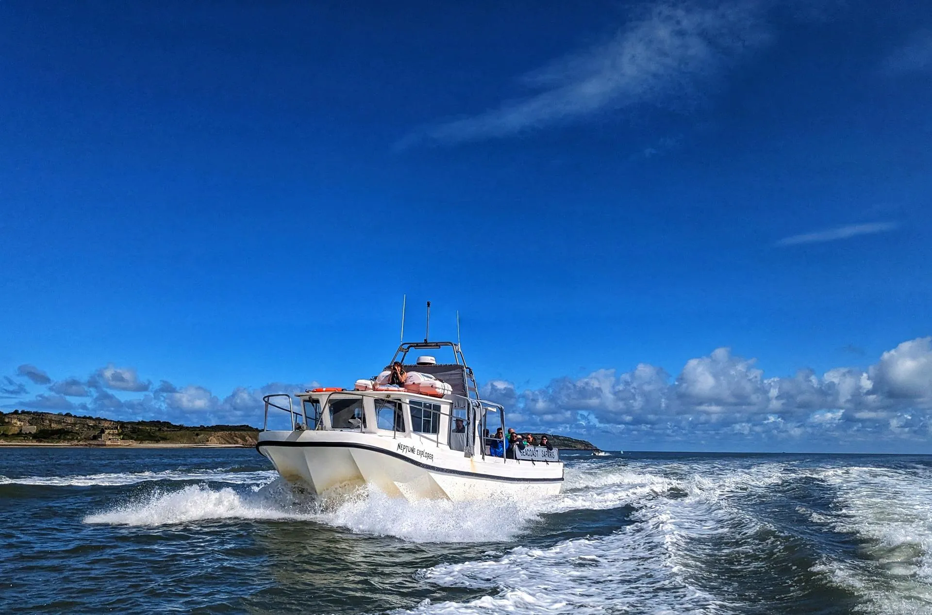 Beautiful blue sky with the seacoast safari boat on the water