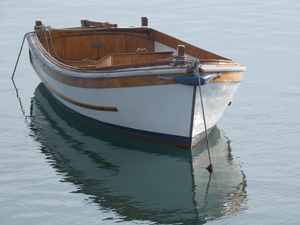 A motor launch moored in Menai Strait with reflection in the water