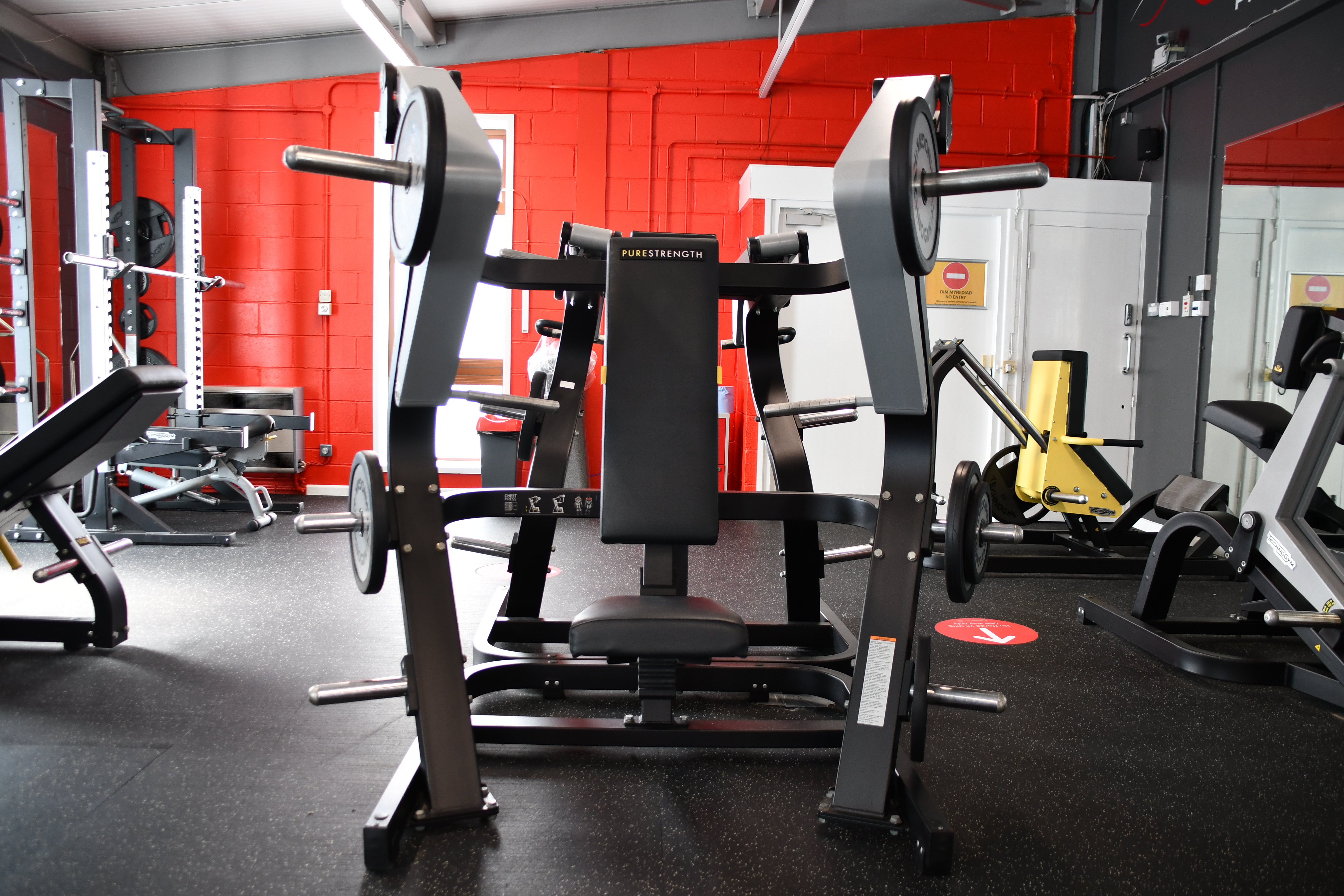 new weights room showing weight lifting machines and red walls