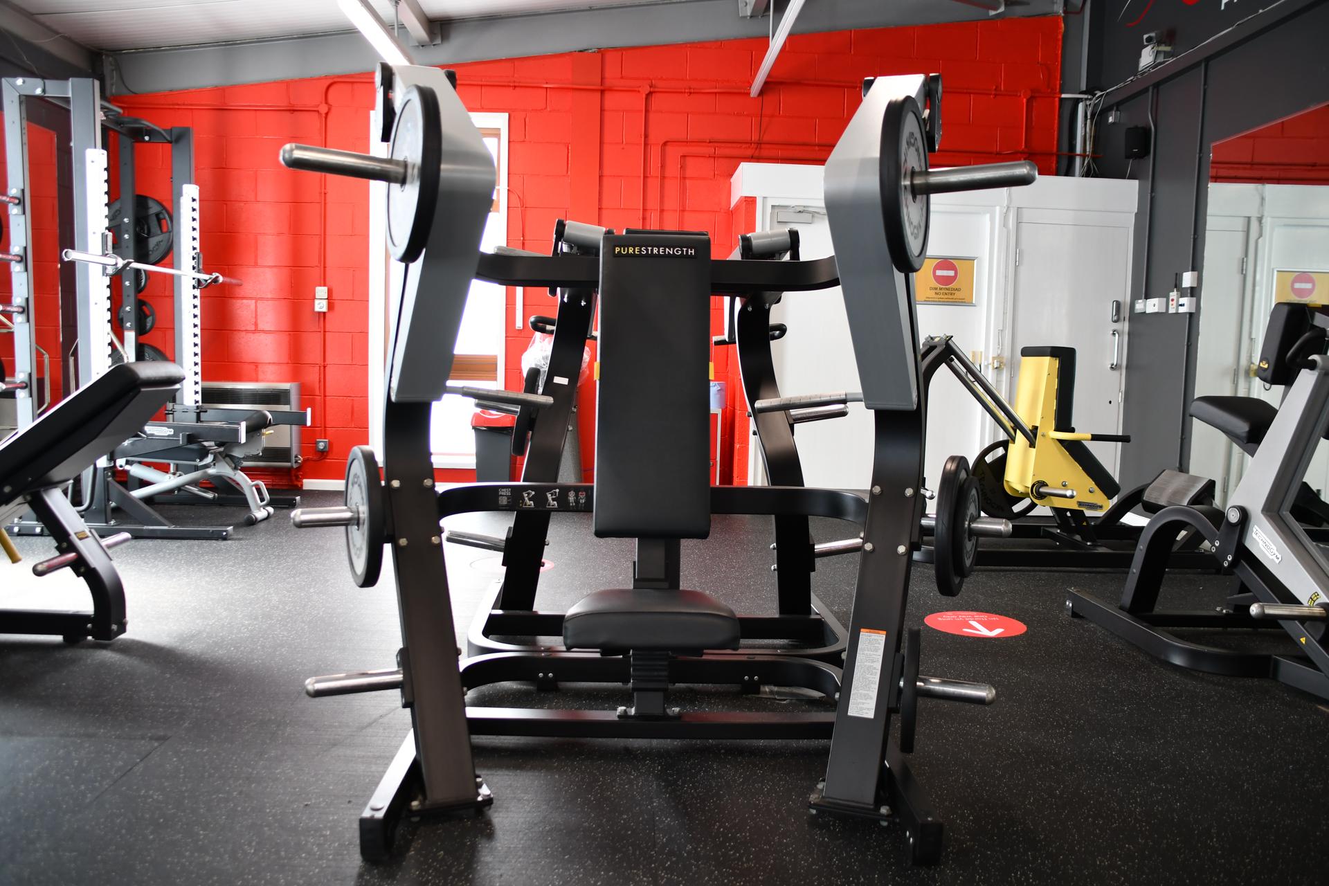 new weights room showing weight lifting machines and red walls