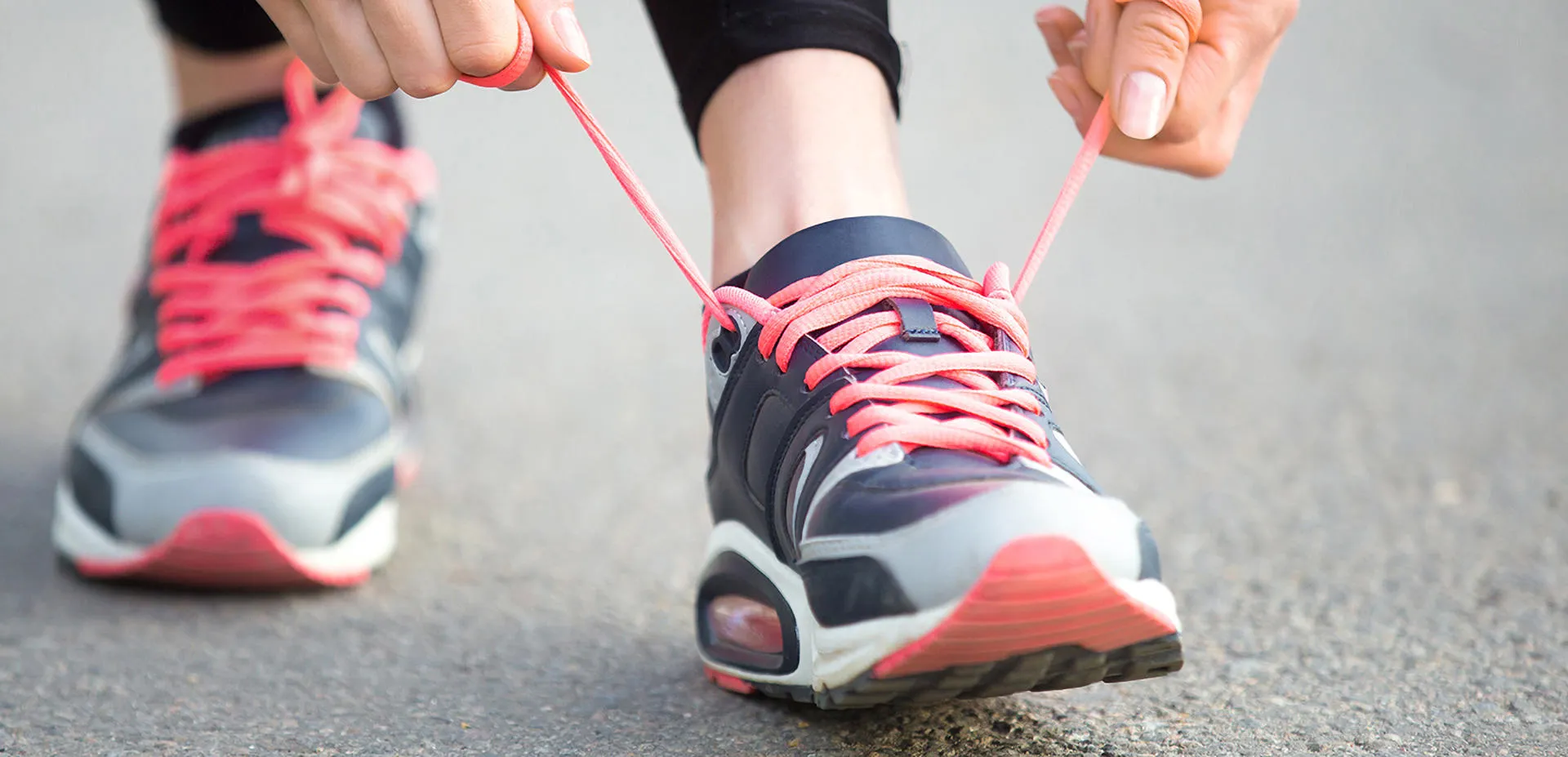 A person tying their laces on running trainers