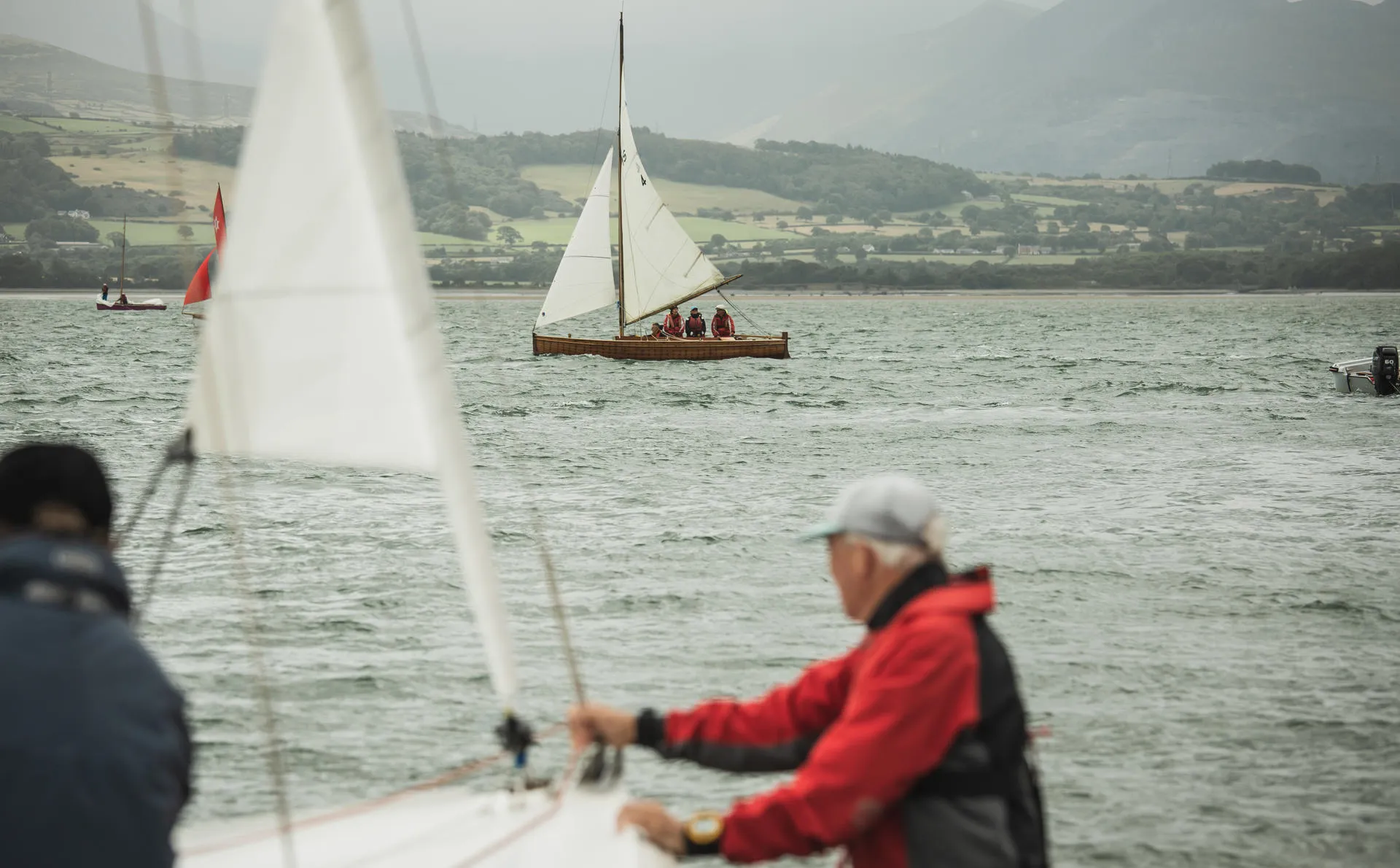Person holding boat forestay ready to launch to windy sea