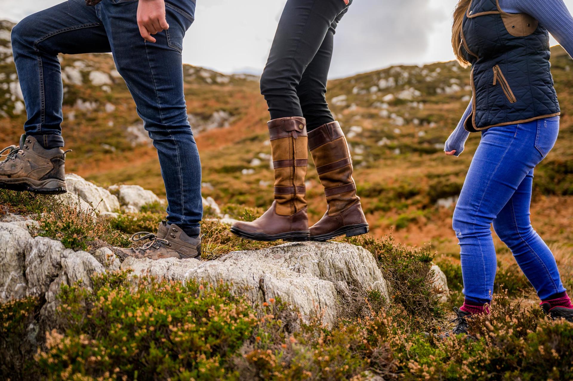 Close up of a group of walkers' legs on a rocky path