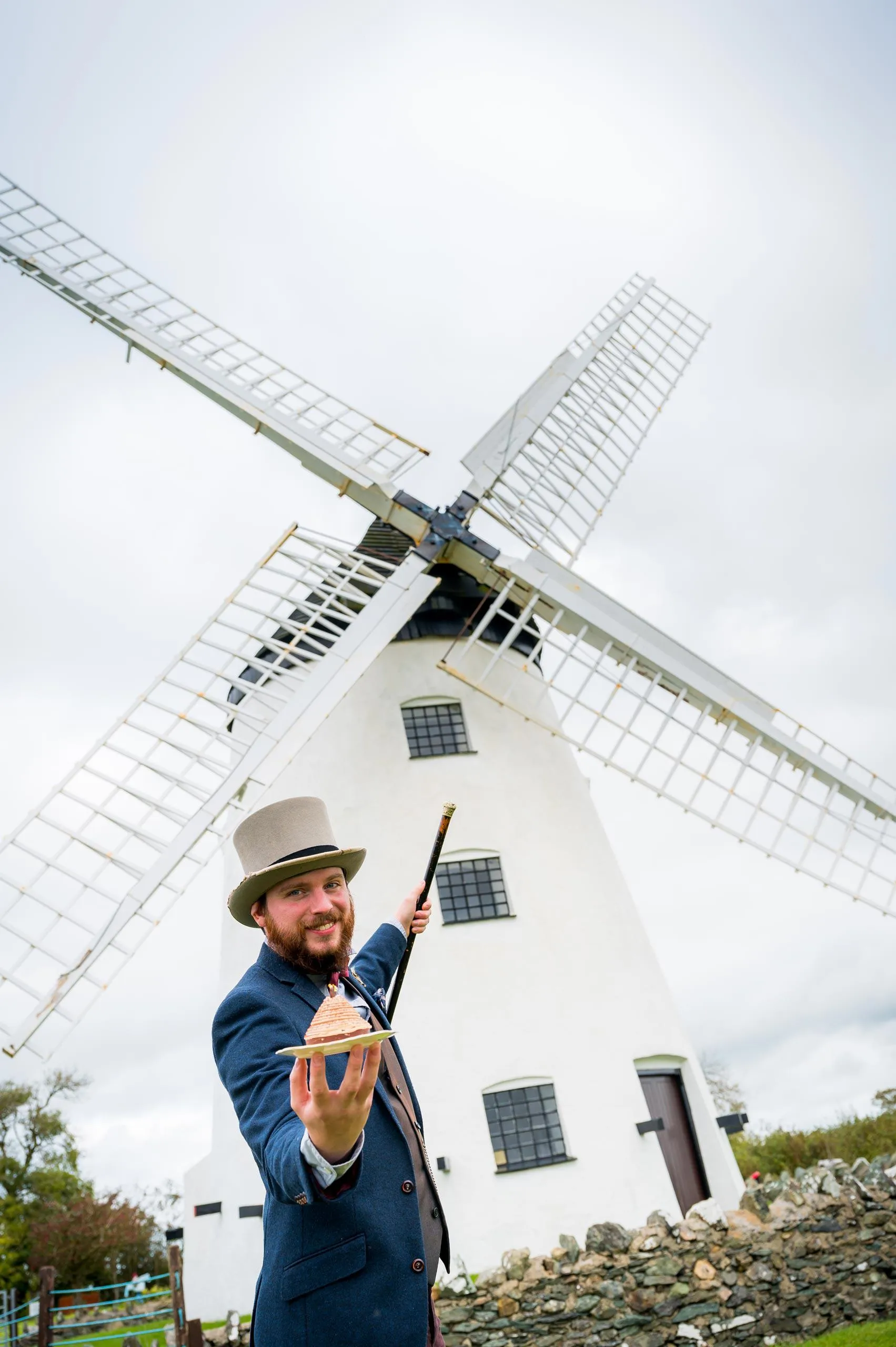 Richard Holt holding a cake with Melin Llynon in the background