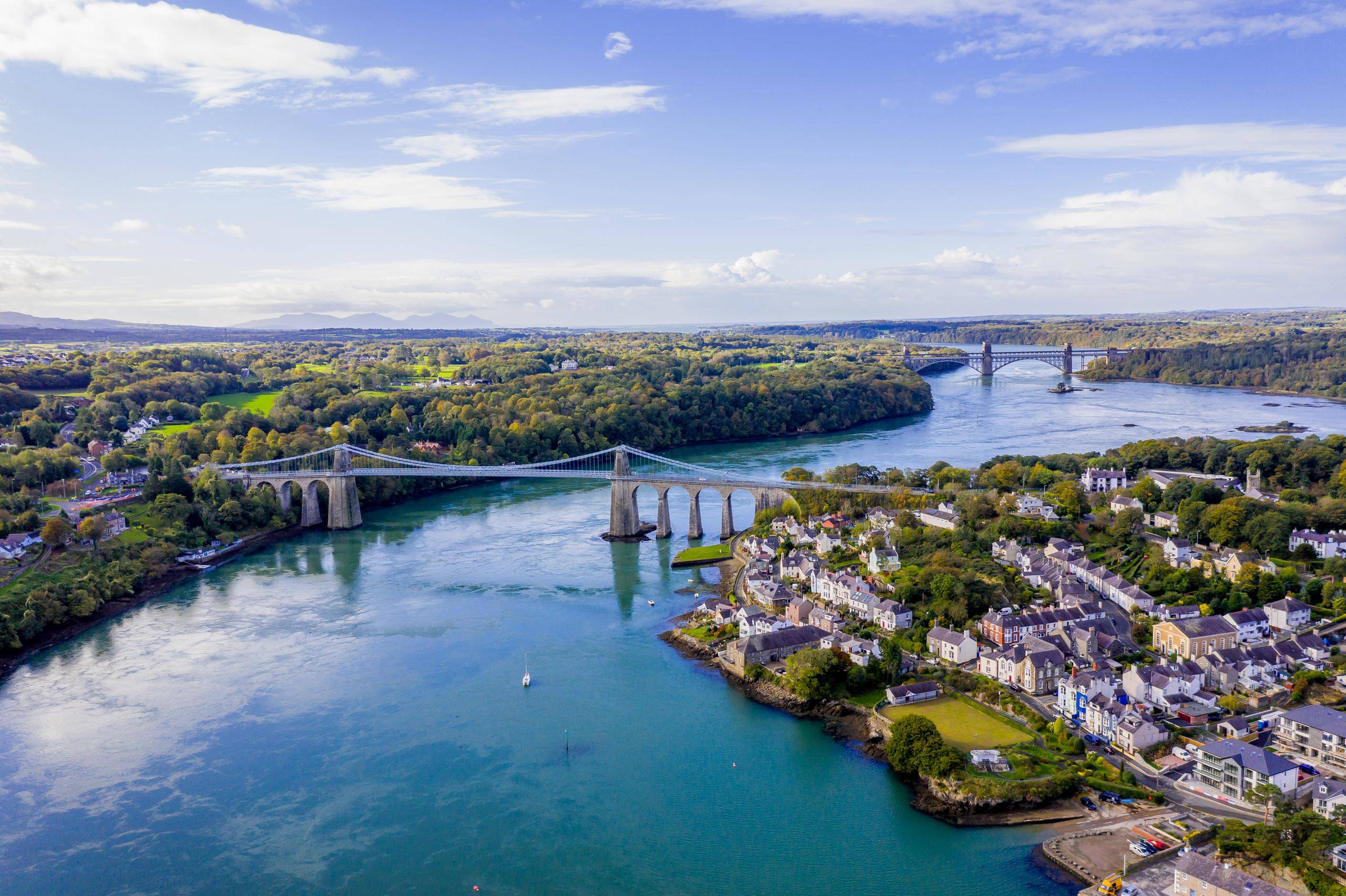 Aerial image of the Menai bridge on a clear day showing the link span and pillars with the Strait underneath