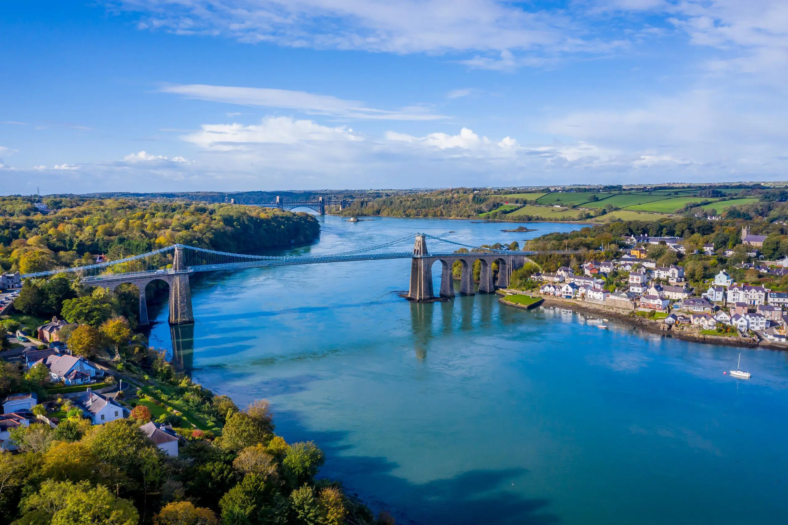 Aerial image of the Menai Strait showing Menai bridge in foreground and Brittania bridge behind 