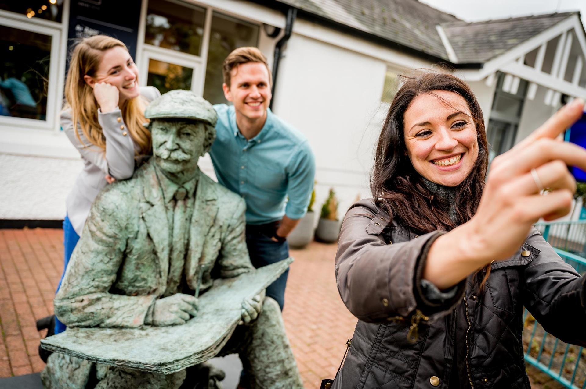 Group of friends around a statue of landscape artist Sir Kyffin Williams