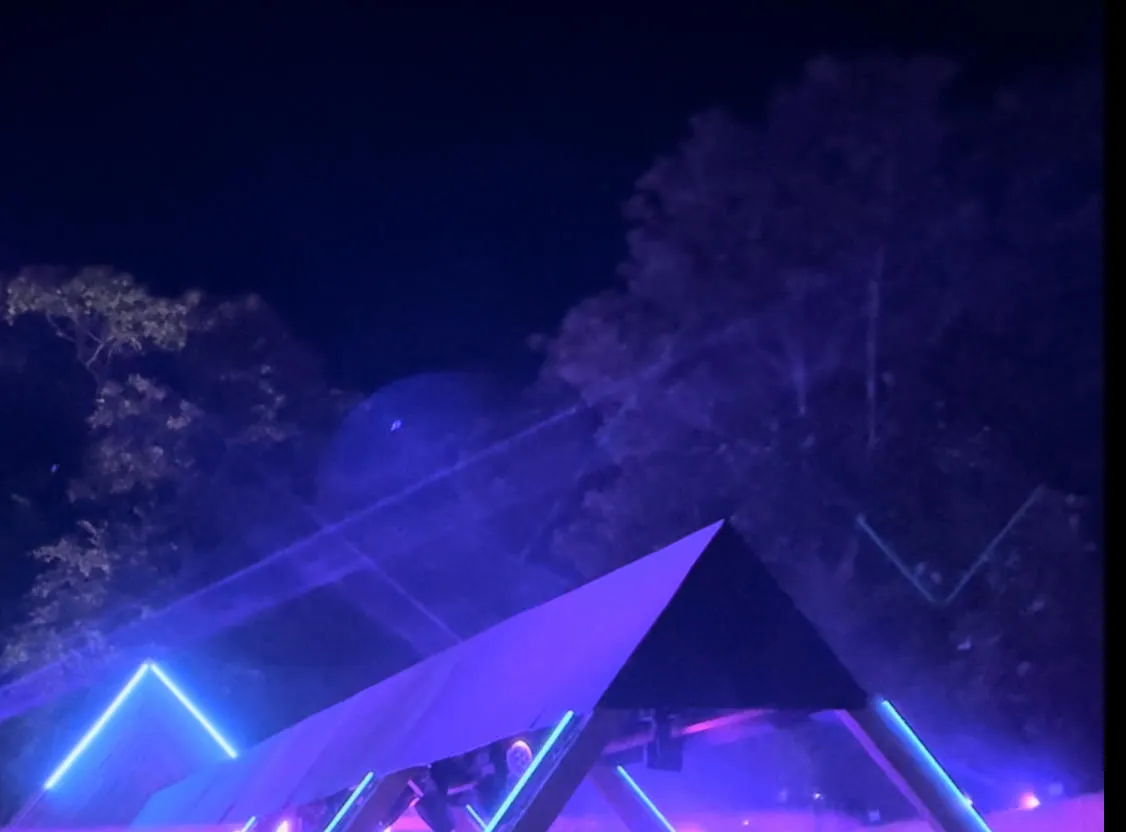 Blue lit festival stage with dancers all around