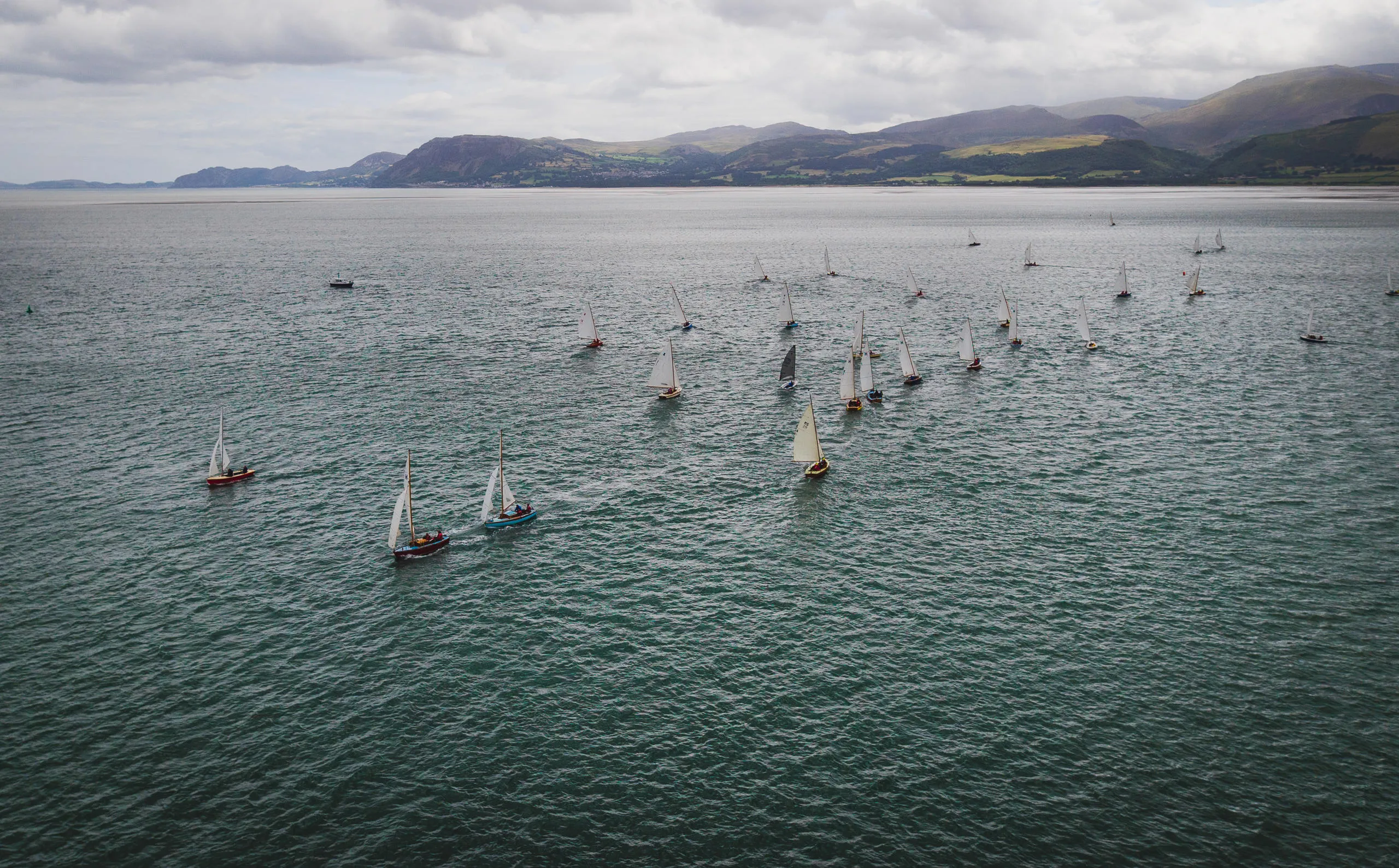 Sailboats racing on Edge of Menai Strait with mountain behind