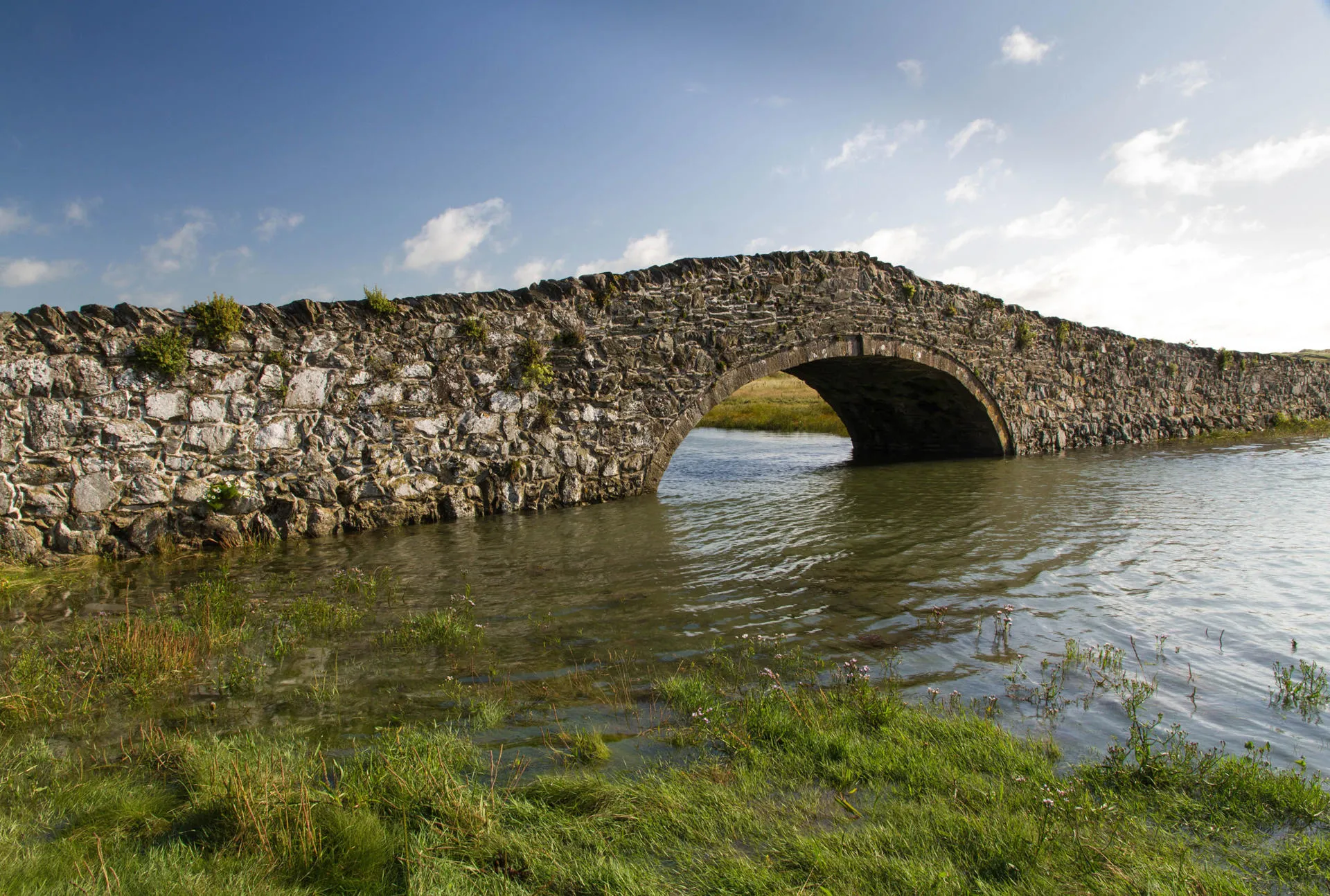 Pont Aberffraw a single span hump-backed built in 1731 and has a segmental arch with dressed stone.