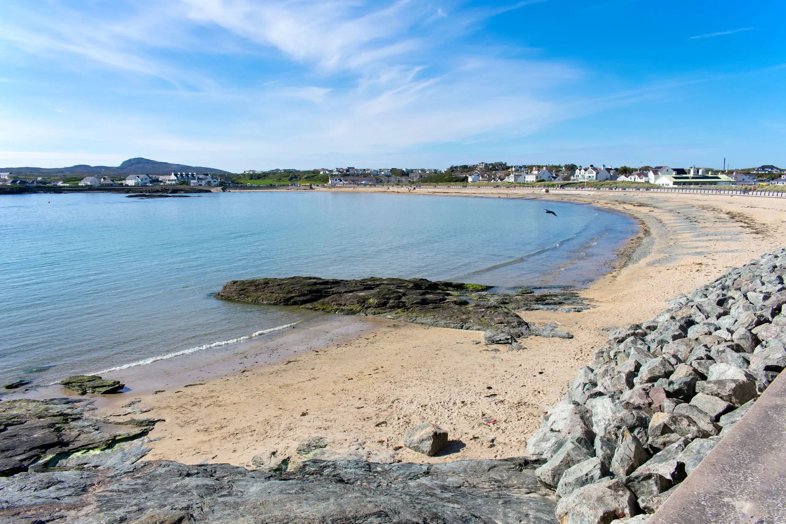 Trearddur bay beach showing the sandy bay and rock armour just underneath our feet