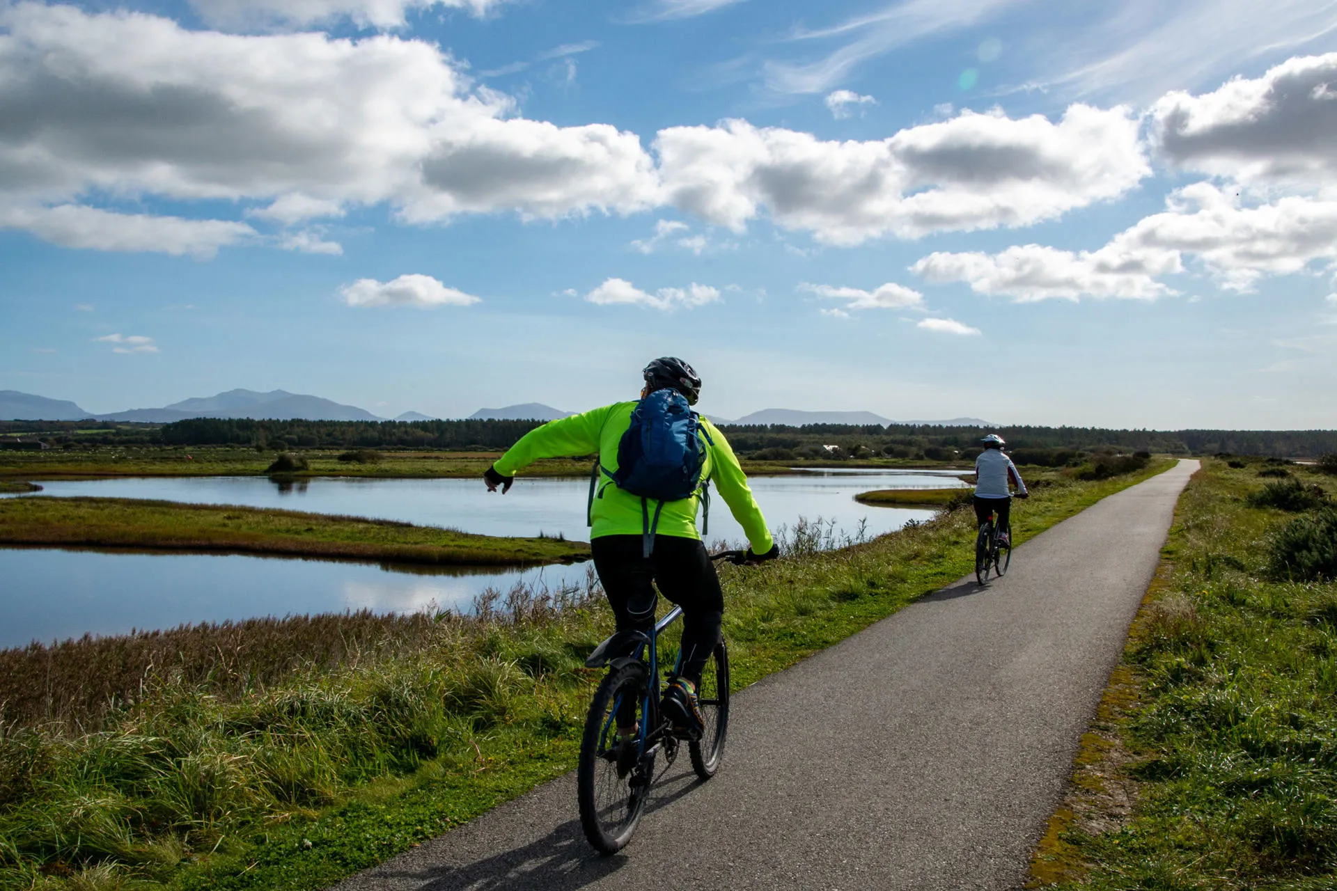 Cyclist riding along the Cob in Malltraeth