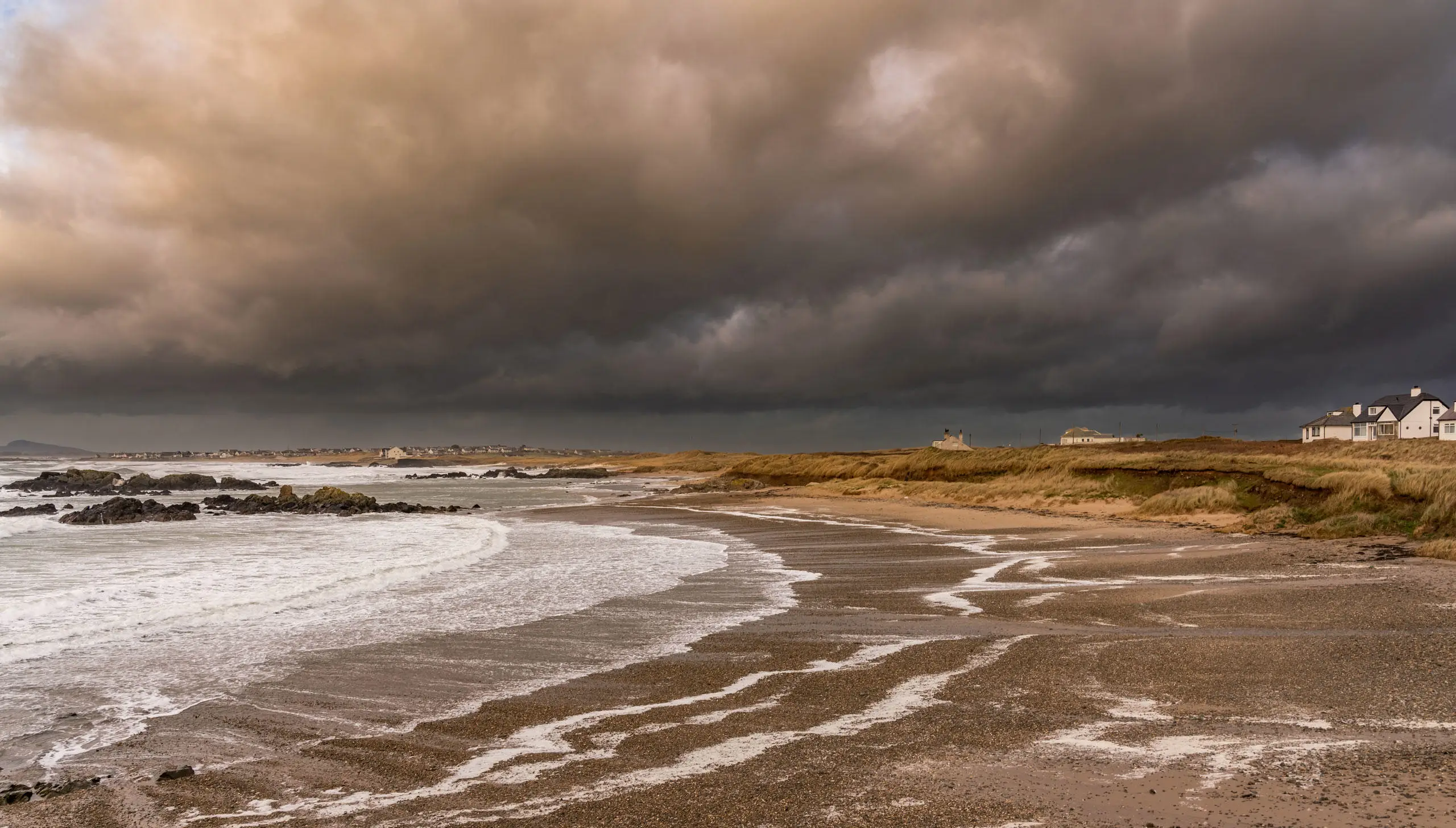 Traeth Rhosneigr cymylau tywyll a tonnau