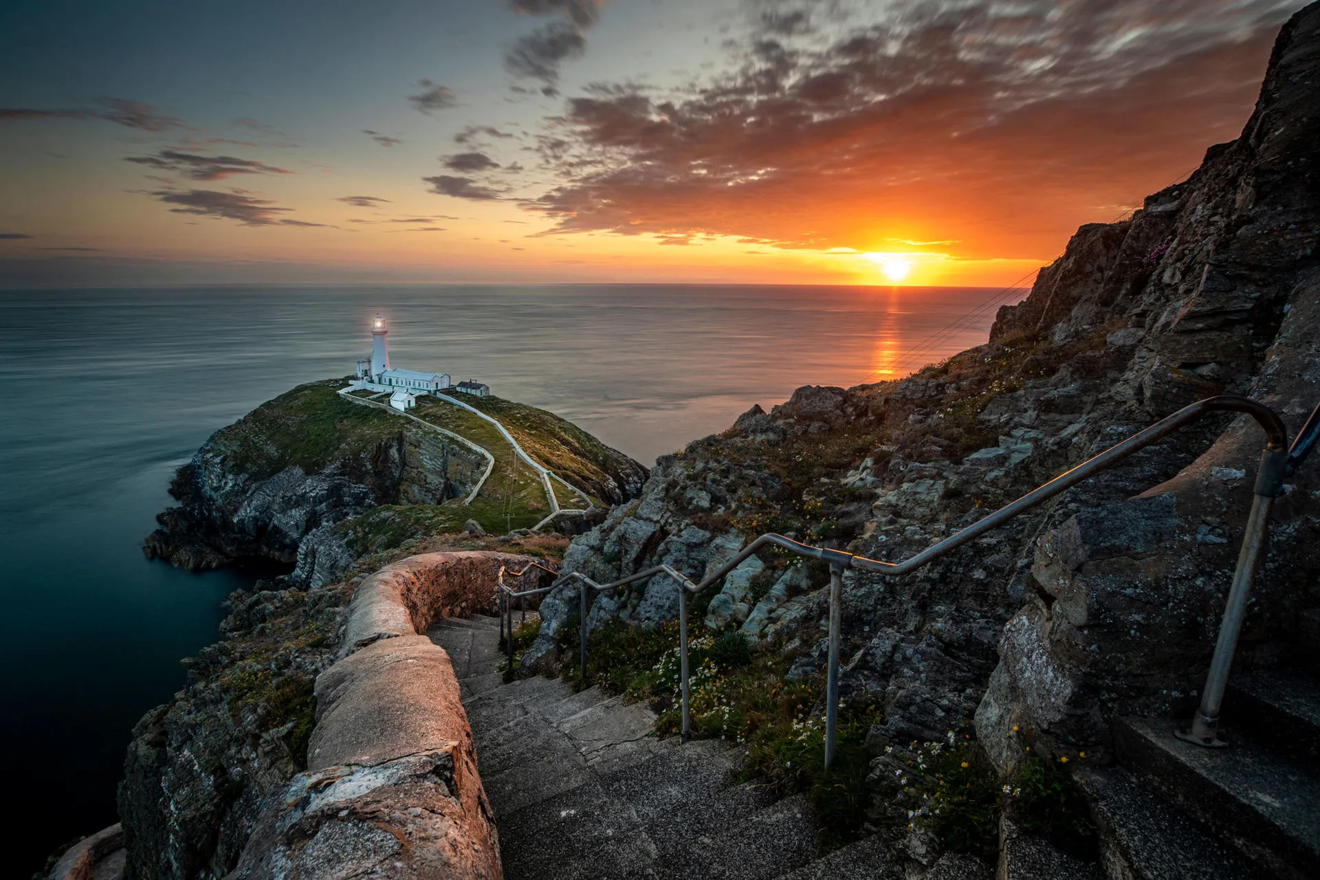 Steep steps leading to South Stack at sunset with the lighthouse