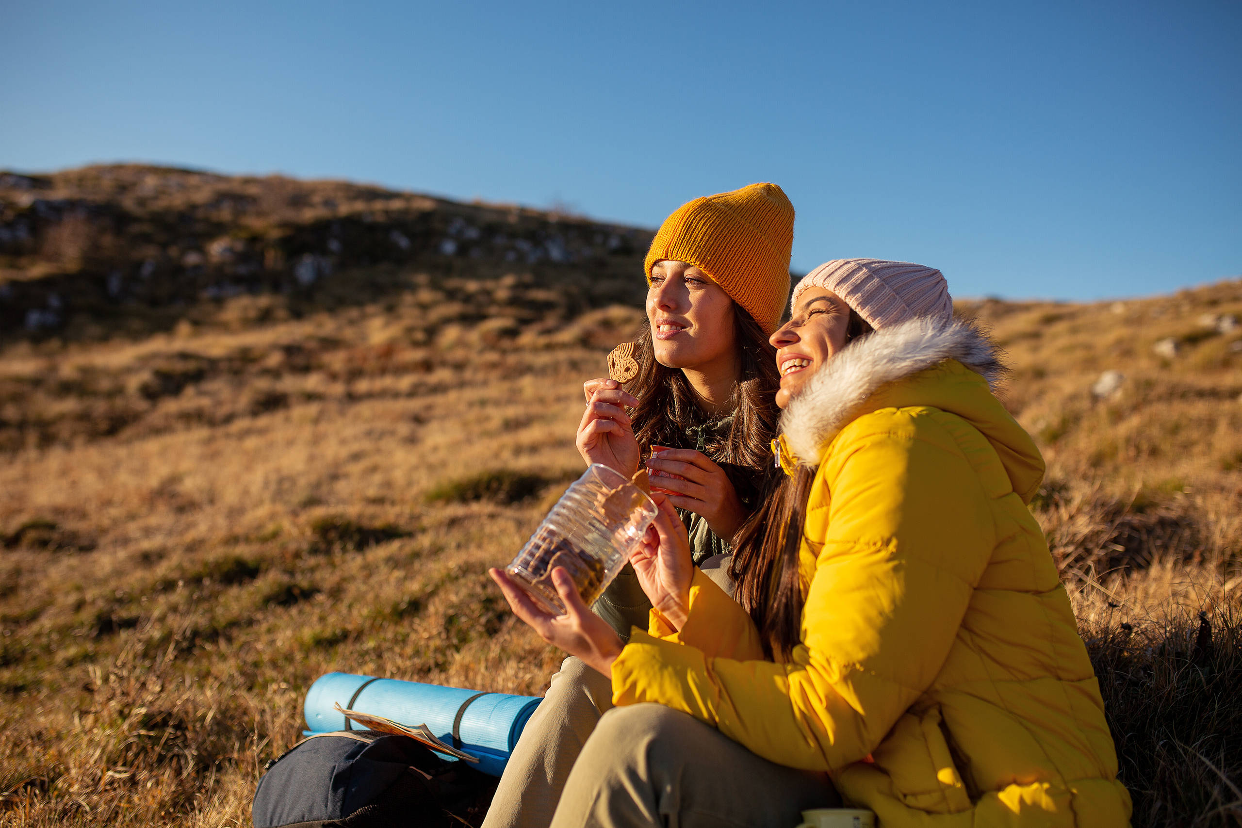 Two women snacking on cookies whilst hiking